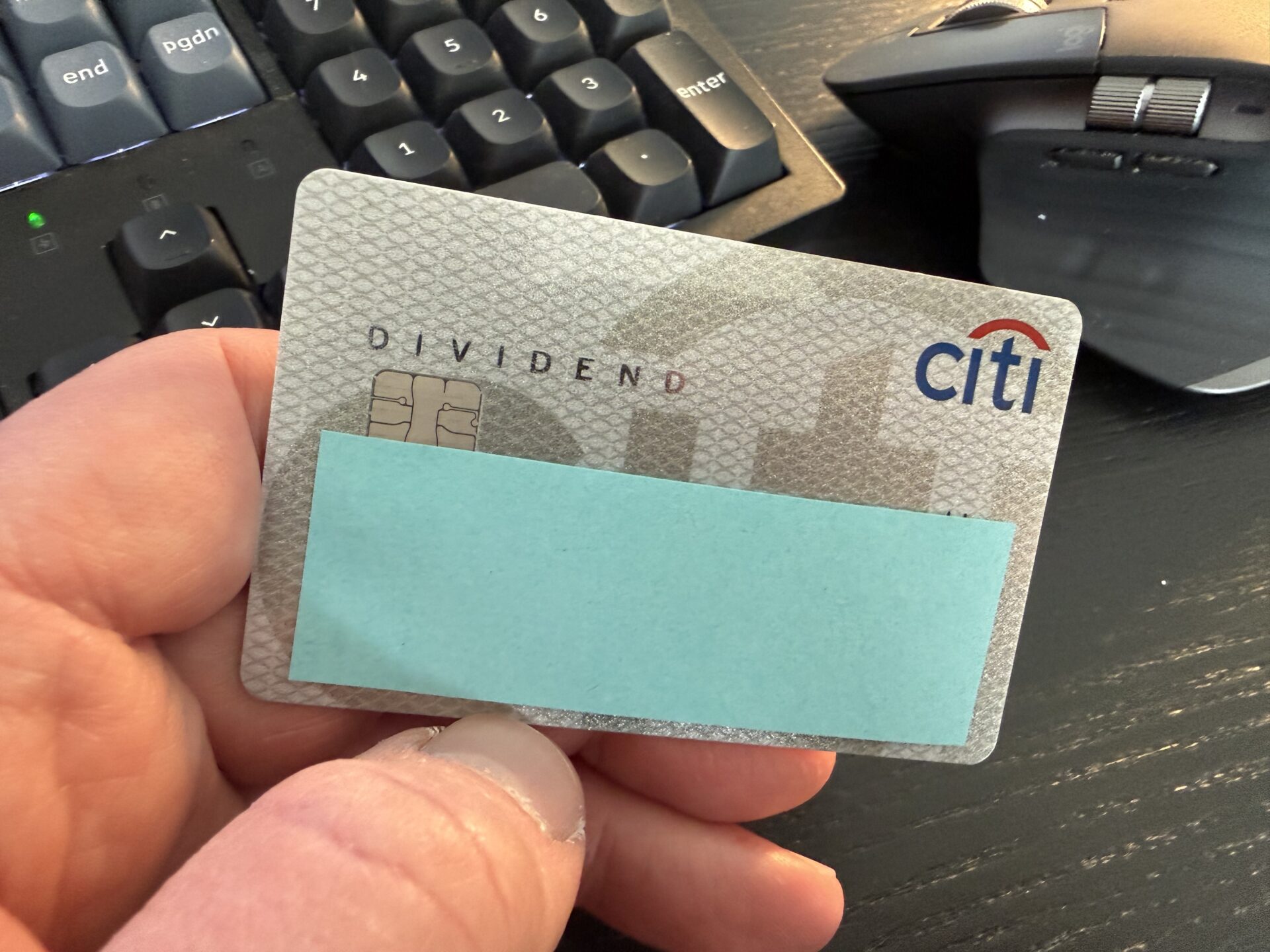 A hand holding the Citi Dividend credit card.